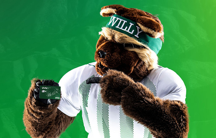 Willy the Wolverine points to a UCCU Wolverine Card.