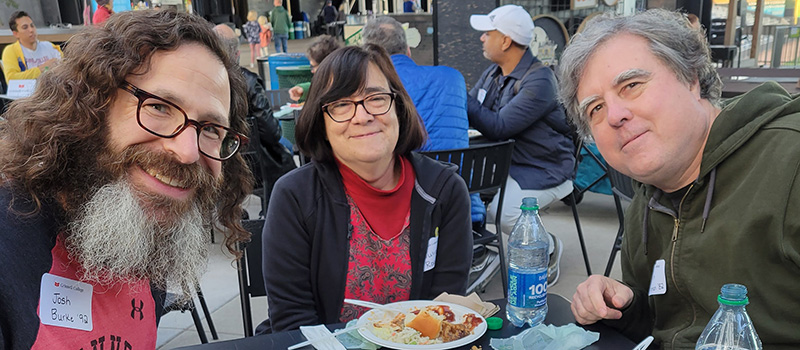 Three alumni enjoy food and conversation during a Twin Cities event.