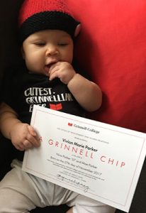 Vivian Parker with her chip certificate while wearing a "Cutest Grinnellian Ever" onesie.