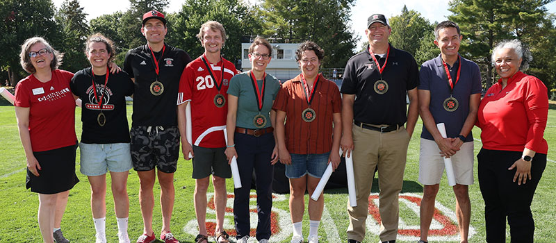President Anne F. Harris and Director of Athletics Holly Roepke pose with the 2024 Athletics Hall of Fame inductees.
