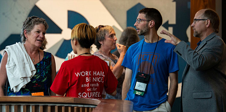 Rich Whitney and Nathan Williams ’03 chat in the HSSC Atrium.