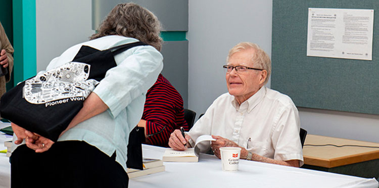 President Emeritus George Drake ’56 signs a copy of his new book.