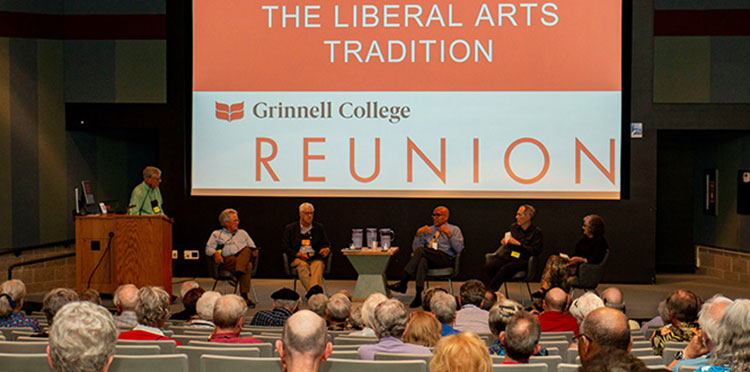 A group of alumni sit on stage with President Raynard Kington during a panel discussion.