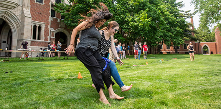 Erin Higgins ’09, left, and Rachel Walwood ‘09 jump while tied together as part of the three-legged long jump.