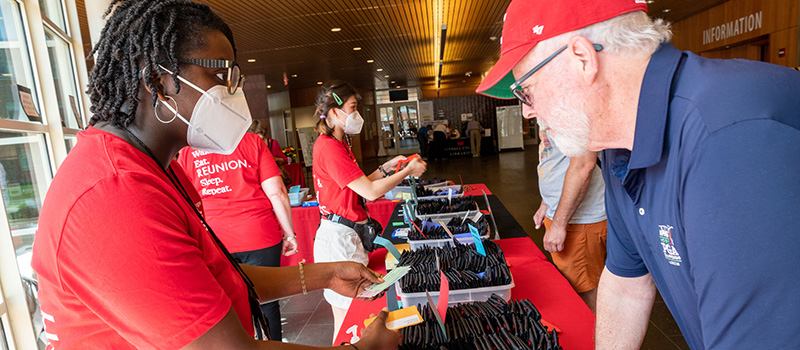 A student work helps an alumnus get checked into Reunion.