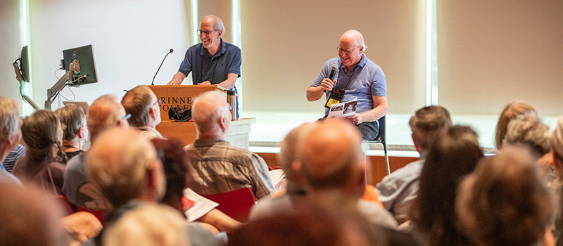 Class Agent David Hechler '72 and Peter Keepnews '72 in front of a packed house in JRC101.