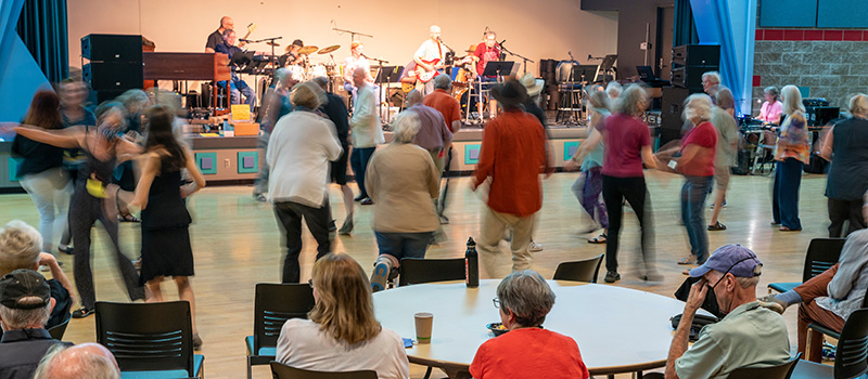 Members of the 50th Reunion Class dance while a band plays on the stage in the Harris Center.