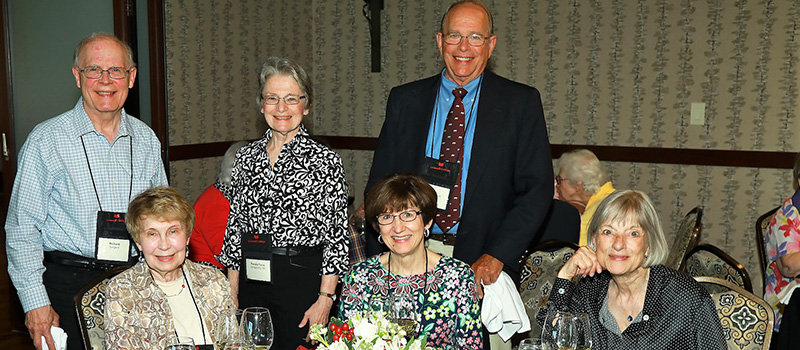 Richard Sargent, Pamela Tanis Langworthy '65, and Jeri Langham '65 (standing) join Ellie Smith Tyson '65, Marilyn Hays Wilton '65 and Chris Verner Coolidge '65 (sitting) for a photo.