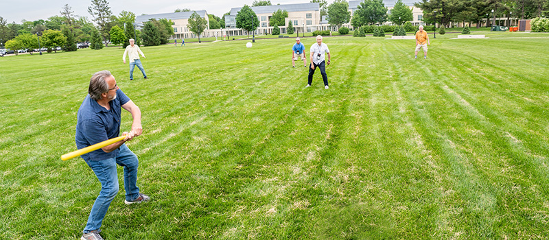 Alumni break out in a game of wiffle ball.