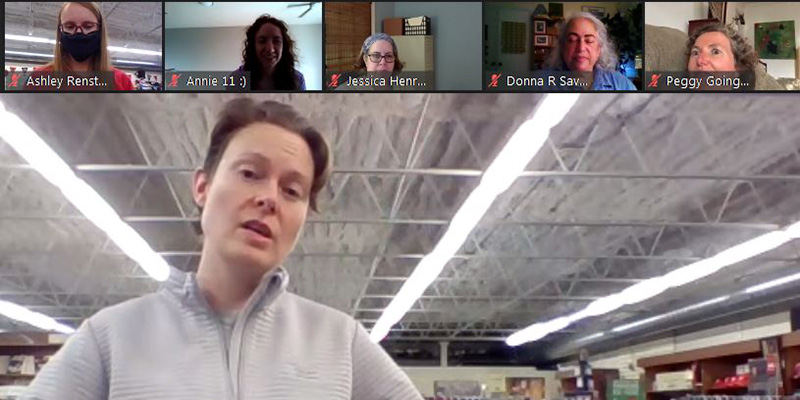 Rachel Edwards Harvith ’00 in the main screen with others in the smaller screens of a zoom call while she models a Grinnell sweater.