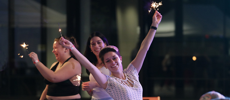 Jade Bustamante '20 holds a sparkler high in the evening air.