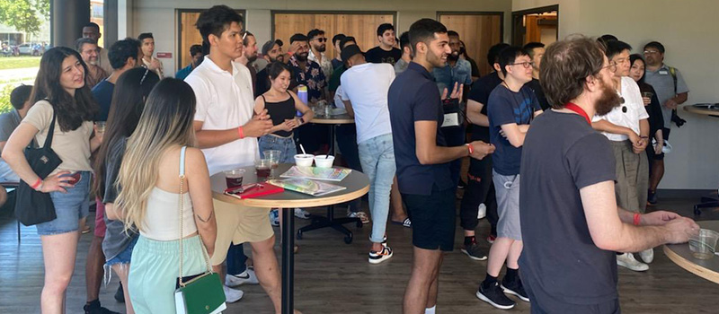 International Young Alumni chat while enjoying snacks and drinks during a special reception.
