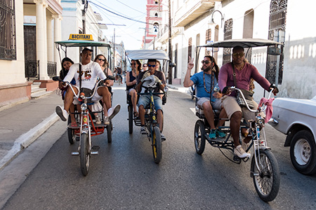 Students ride in the back of a rickshaw while traveling as part of course embedded travel.