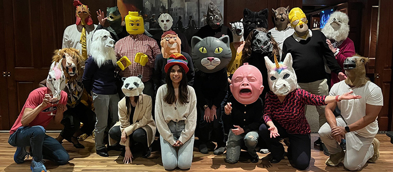A group photo of the Alumni Council while wearing various fun masks.