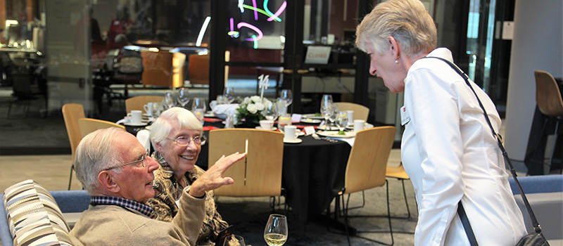 Jo Sunnen Sly ’54 and Skip Sly ’54 chat with Associate Professor Monessa Cummins.