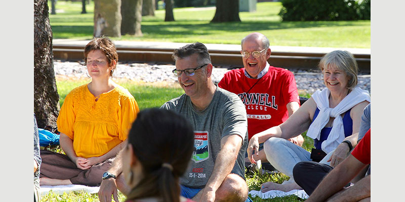 Grinnellians of all ages giggle and smile while practicing laughter yoga.
