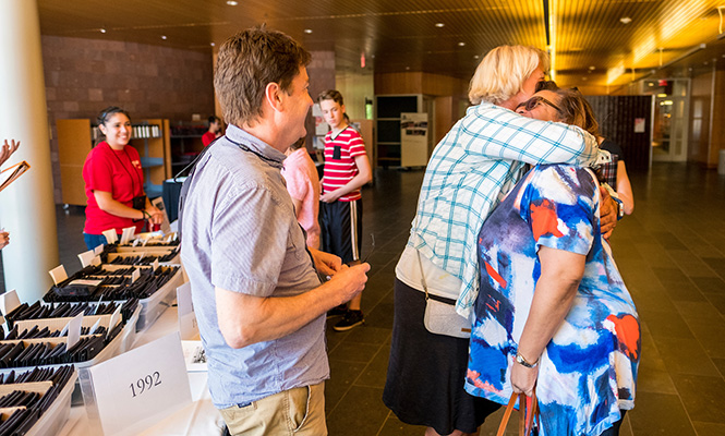 Two alumnae embrace at the registration table in the JRC.