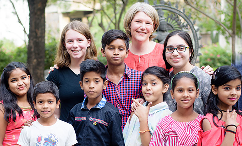 Shayne Beschta ’95, top, poses with some children from the Viiveknand community in New Delhi, India. Beschta’s project will rehabilitate a neighborhood library.