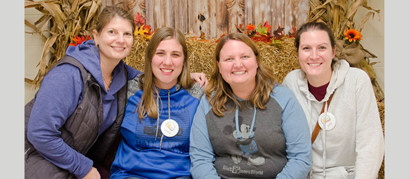 Carrie Fetzner Ramirez ’97, second from right, sits for a group photo with other board members of the East Olive Community Center.
