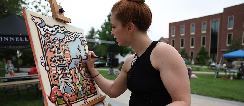 Kathleen Roling, paints an original piece during Block Party.