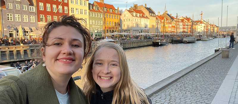 A student and her externship host pose along the canal in Amsterdam.