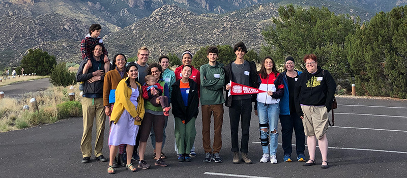 A group of Alumni from New Mexico pose as a group in front of the mountains.
